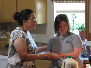 Direct Support Professional and Vicky prepare breakfast together.